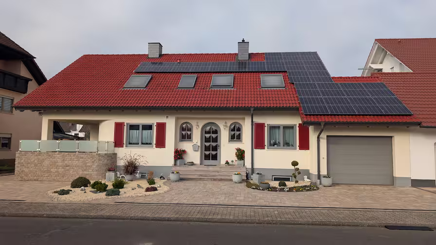 Neu gestrichene Wohnhausfassade in Weiß mit roten Akzentflächen